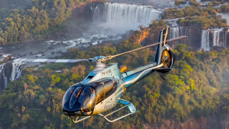 Helicopter flying over a tropical waterfall